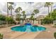 Beautiful pool area featuring clear blue water, palm trees, lounge chairs, and nearby buildings at 8989 N Gainey Center Dr # 231, Scottsdale, AZ 85258