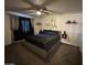 This bedroom features a ceiling fan, dark carpet, a large bed and modern decorations at 948 S Alma School Rd # 115, Mesa, AZ 85210