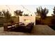 Inviting outdoor living area featuring an open fireplace, comfortable seating, and ambient string lighting at 11818 W Luxton Ln, Avondale, AZ 85323