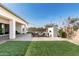 Relaxing backyard patio area complete with an outdoor fireplace, comfortable seating, and lush landscaping at 11818 W Luxton Ln, Avondale, AZ 85323