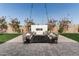 Inviting backyard patio area with outdoor fireplace and lounge seating under decorative string lights at 11818 W Luxton Ln, Avondale, AZ 85323