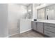 Bright bathroom features a spacious walk-in shower, a gray vanity and hardwood floor at 11818 W Luxton Ln, Avondale, AZ 85323