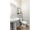 A stylish powder room has decor, a white pedestal sink and toilet at 11818 W Luxton Ln, Avondale, AZ 85323