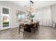 Bright dining room with a modern chandelier and view to the landscaped backyard at 11818 W Luxton Ln, Avondale, AZ 85323