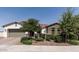 Charming single-story home boasts a well-manicured front yard, stone accents, and a two-car garage at 11818 W Luxton Ln, Avondale, AZ 85323
