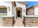 Inviting home exterior features manicured stone entryway, neutral color scheme, and two-car garage at 11818 W Luxton Ln, Avondale, AZ 85323