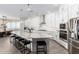 Bright kitchen features white cabinets, granite counters, a large island, and stainless steel appliances at 11818 W Luxton Ln, Avondale, AZ 85323