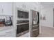Modern kitchen features stainless steel appliances, white cabinets, and granite countertops at 11818 W Luxton Ln, Avondale, AZ 85323