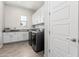 Functional laundry room with a sink, counter space, and modern washer and dryer at 11818 W Luxton Ln, Avondale, AZ 85323