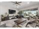 Comfortable living room featuring backyard access through a sliding glass door and ceiling fan at 11818 W Luxton Ln, Avondale, AZ 85323