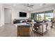 Open-concept living room with tiled floors, a ceiling fan, and a sliding glass door to the backyard at 11818 W Luxton Ln, Avondale, AZ 85323