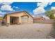 Gravel backyard offers low maintenance landscaping with a covered patio and clear view of the home's exterior at 12371 W Hadley St, Avondale, AZ 85323