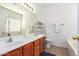 Bathroom featuring double sinks with wood cabinets and a shower-tub combo at 12371 W Hadley St, Avondale, AZ 85323