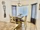Cozy dining area with a square table, four chairs, stylish chandelier and bright natural light at 12371 W Hadley St, Avondale, AZ 85323