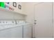 Laundry room features a washer, dryer, upper shelves, and access to the exterior at 12371 W Hadley St, Avondale, AZ 85323