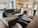 Spacious living room with a large sectional couch, stylish rug, and open access to the kitchen at 12371 W Hadley St, Avondale, AZ 85323