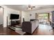 Bright living room featuring a dark grey couch, wood flooring and natural light from the sliding glass door at 12371 W Hadley St, Avondale, AZ 85323
