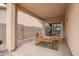 Covered patio featuring neutral tones with outdoor seating and sliding glass door access to the home's interior at 12371 W Hadley St, Avondale, AZ 85323