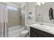 Neutral toned bathroom features a shower and bathtub combination with a gray vanity at 13204 W Via Dona Rd, Peoria, AZ 85383