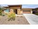 Inviting desert home featuring a two-car garage, covered front entrance, and low-maintenance landscaping at 13204 W Via Dona Rd, Peoria, AZ 85383