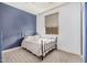 Bedroom with tile flooring, neutral walls, window and iron bed frame at 15573 W Laurel Ln, Surprise, AZ 85379