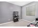 Bedroom with gray walls, neutral flooring, and a simple black shelf unit, providing a minimalist and functional space at 15573 W Laurel Ln, Surprise, AZ 85379