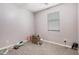 Neutral-toned bedroom with tiled floors and ample natural light from the window, offering a blank canvas at 15573 W Laurel Ln, Surprise, AZ 85379
