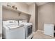 Laundry room with side-by-side washer and dryer, overhead shelving, and an additional chest freezer at 15573 W Laurel Ln, Surprise, AZ 85379