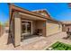 Outdoor patio with sliding glass door, seating, and neutral color scheme at 15573 W Laurel Ln, Surprise, AZ 85379
