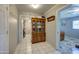 Hallway view with white tiled floors, an antique wood china cabinet, and doorways to other rooms at 1740 W Crescent Ave, Mesa, AZ 85202