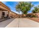 Spacious backyard featuring a basketball hoop, fire pit, patio, and mature trees at 17538 W Marshall Ln, Surprise, AZ 85388