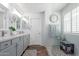 Bathroom featuring double sinks, quartz countertops, modern fixtures, and a glass-enclosed shower at 17538 W Marshall Ln, Surprise, AZ 85388