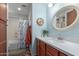 Cozy bathroom with a wooden vanity, quartz countertop, and a shower-tub combo at 17538 W Marshall Ln, Surprise, AZ 85388