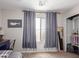 Cozy bedroom with carpet flooring, a window with curtains, and a closet at 17538 W Marshall Ln, Surprise, AZ 85388