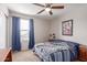 Bright bedroom features a ceiling fan, large window, and carpet flooring at 17538 W Marshall Ln, Surprise, AZ 85388