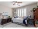 This bedroom features a ceiling fan and a bright window with shutters at 17538 W Marshall Ln, Surprise, AZ 85388