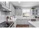 Bright kitchen features white cabinets, stainless steel appliances, and a window over the sink at 17538 W Marshall Ln, Surprise, AZ 85388