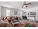 Bright and spacious living room with comfortable seating, ceiling fan, and multiple windows for natural light at 17538 W Marshall Ln, Surprise, AZ 85388