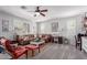 Cozy living room with comfortable seating, neutral carpet, ample natural light, and a ceiling fan at 17538 W Marshall Ln, Surprise, AZ 85388