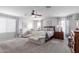 Spacious main bedroom with a ceiling fan, carpet flooring, and natural light at 17538 W Marshall Ln, Surprise, AZ 85388