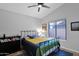 A simple bedroom with cool colors, a ceiling fan, and a large picture window at 18014 N 53Rd Pl, Scottsdale, AZ 85254