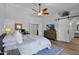 Inviting bedroom with ceiling fan, wood floors, and ensuite bathroom with sliding barn door at 18014 N 53Rd Pl, Scottsdale, AZ 85254