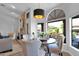 Bright dining area with stone fireplace, modern chandelier, and backyard views at 18014 N 53Rd Pl, Scottsdale, AZ 85254