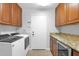 Laundry room with washer, dryer, cabinets, granite countertops, and access to the garage at 18014 N 53Rd Pl, Scottsdale, AZ 85254
