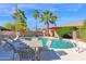 Backyard pool with palm trees, lounge chairs and outdoor dining area under a bright blue sky at 18014 N 53Rd Pl, Scottsdale, AZ 85254