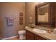 Bathroom with granite countertop, framed mirror, decorative accents and neutral color palette at 19700 N 76Th St # 2001, Scottsdale, AZ 85255
