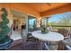 Relaxing covered patio with desert views, ceiling fan and stone table and chairs at 19700 N 76Th St # 2001, Scottsdale, AZ 85255