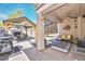 Inviting back patio featuring an outdoor kitchen, fireplace, ceiling fan, comfortable seating, and stylish decor at 20338 N 262Nd Ave, Buckeye, AZ 85396