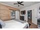 Bright bedroom featuring wood accent wall, TV, closet, and doorway to the ensuite bathroom at 20338 N 262Nd Ave, Buckeye, AZ 85396