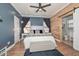 Spacious bedroom featuring barn door entry to bathroom, blue walls, and modern furnishings at 20338 N 262Nd Ave, Buckeye, AZ 85396